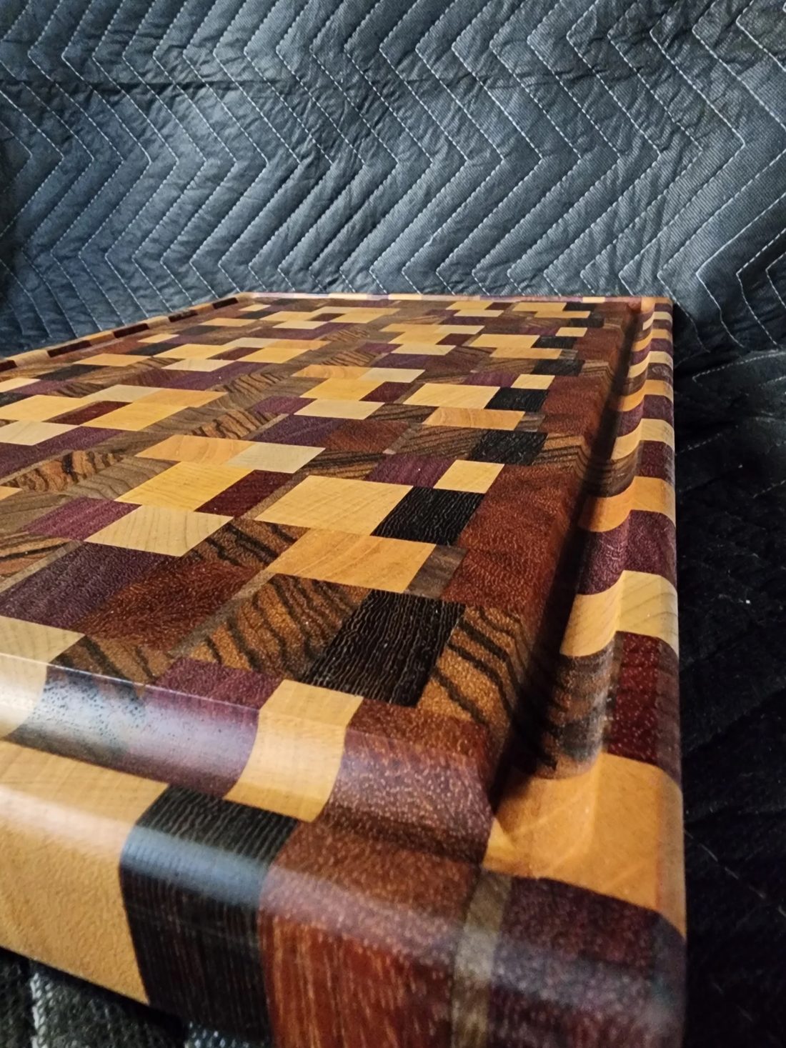 Close-up end-grain cutting board pieced from walnut, maple, and purpleheart in a checkerboard pattern